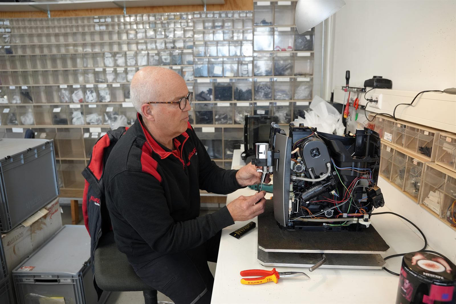 Een monteur van Mix-Fix repareert een koffiemachine in de eigen werkplaats