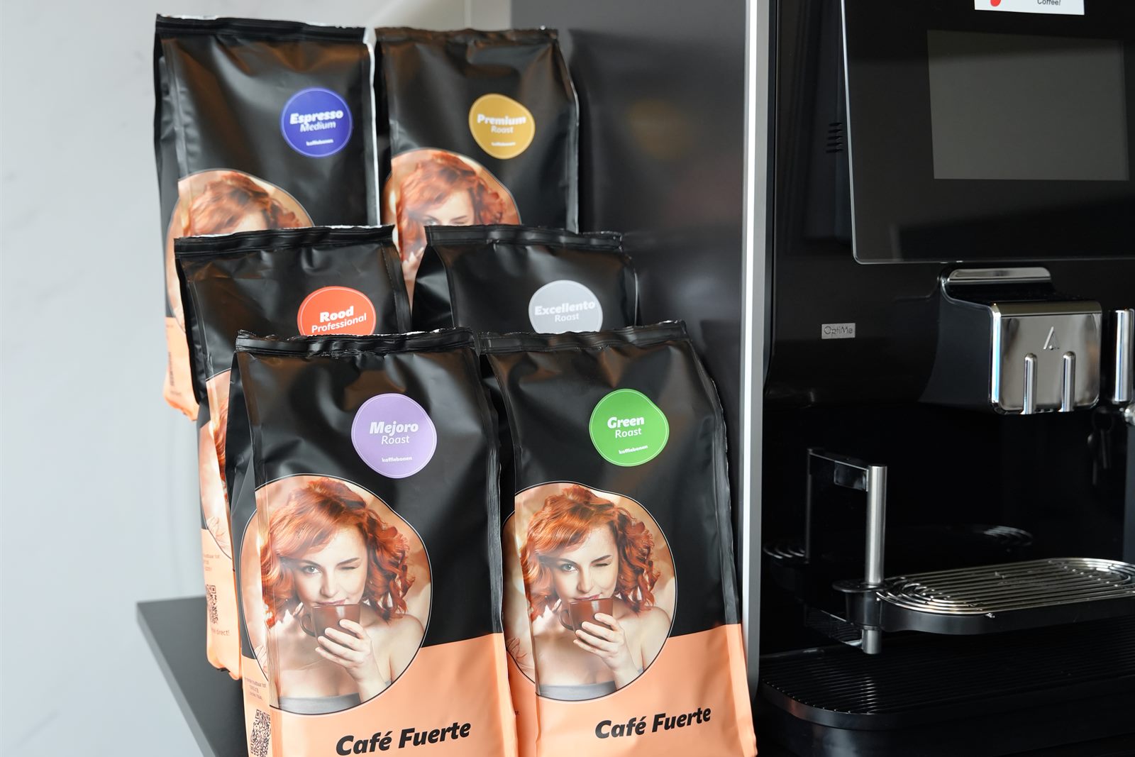 Zakken Café Fuerte-koffie in verschillende blends naast een koffiemachine in de showroom van Mix-Fix